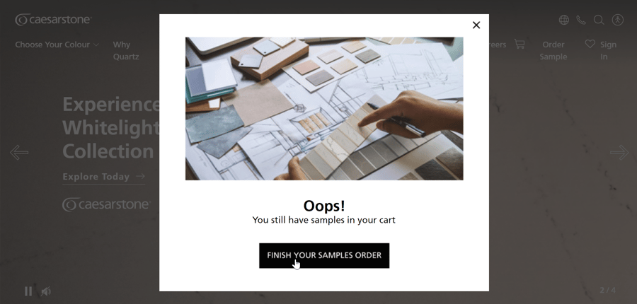 Shopping cart abandonment popup with a "Finish your samples order" CTA, with an image featuring a hand choosing a stone tile from a catalogue. 